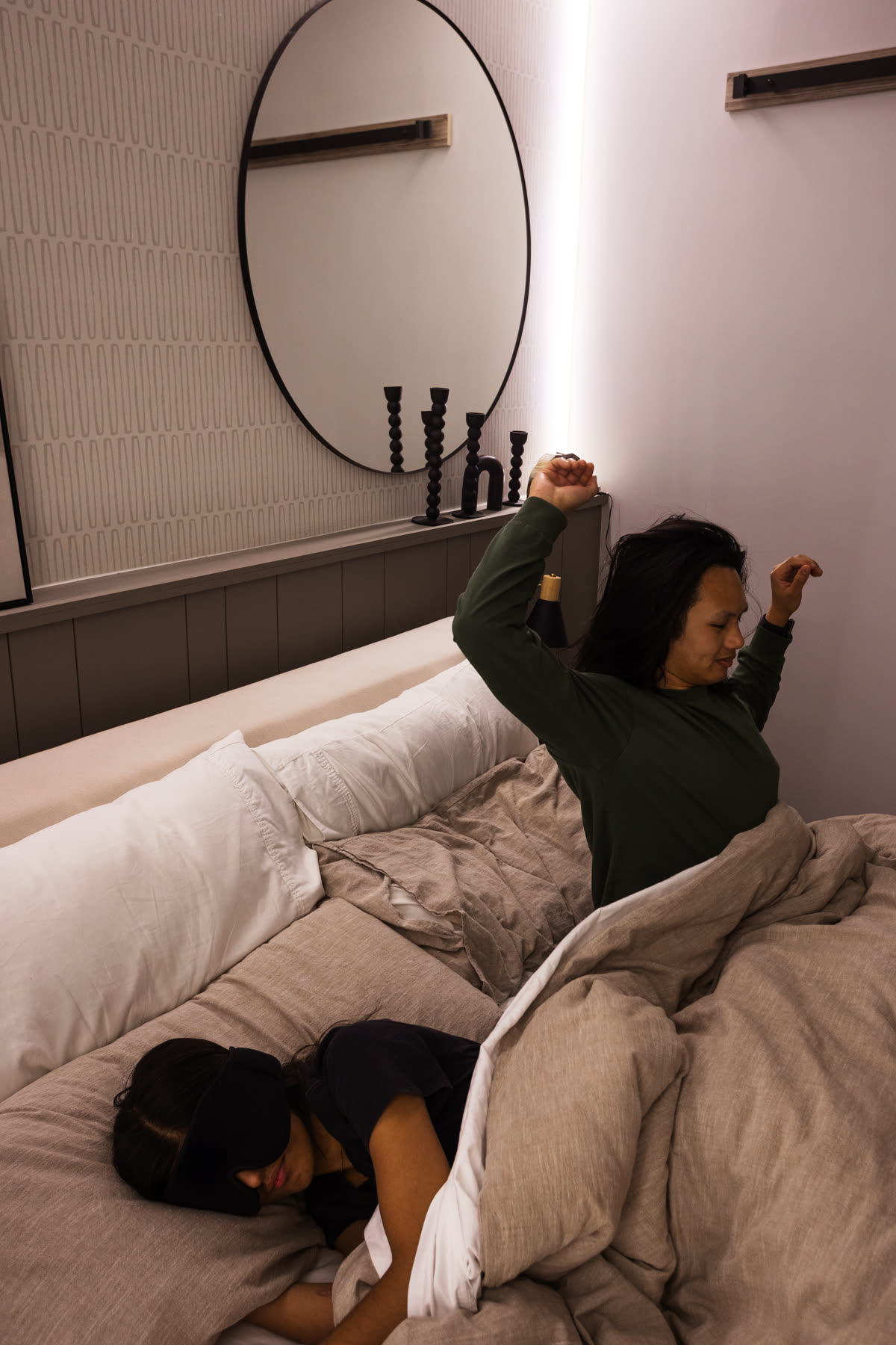 One partner waking gently to the strip's glow while the other sleeps